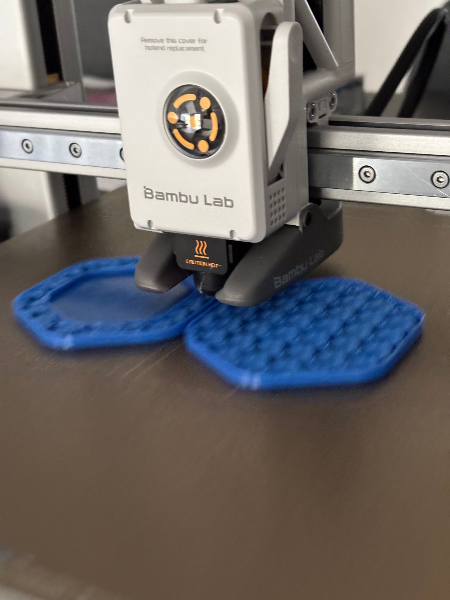 Bambu Lab 3D-printer med blå printede objekter på printpladen